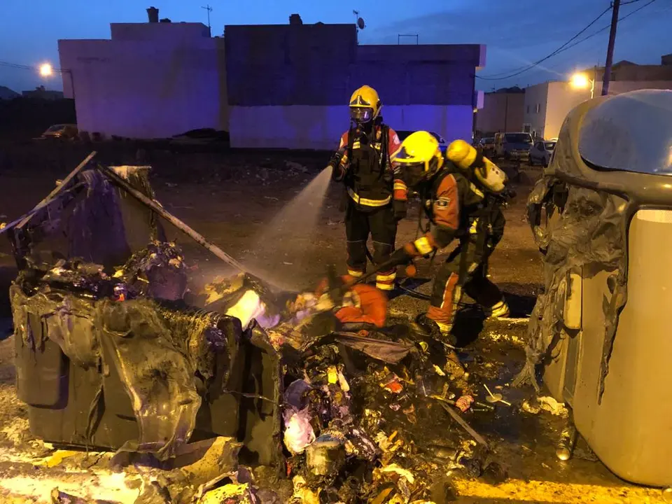 Bomberos apagando contenedores