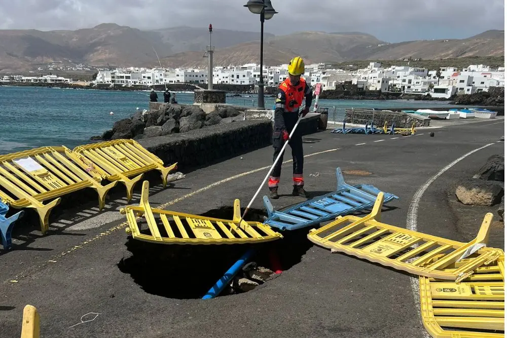 Los bomberos colocando las vallas en el socavón de Punta Mujeres