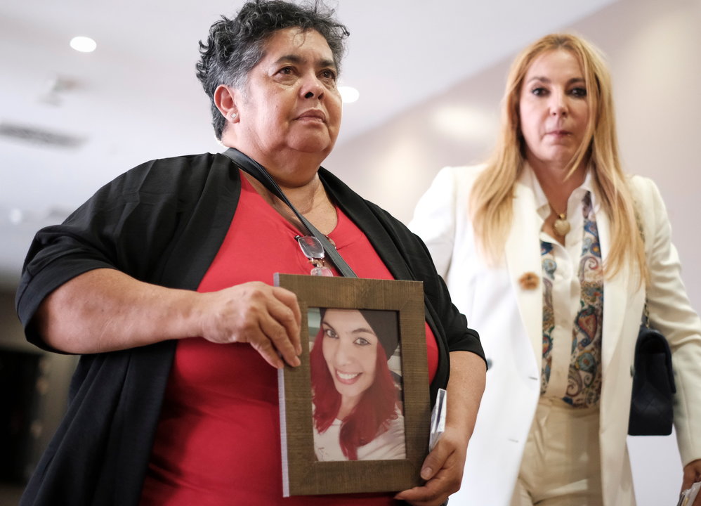 Míriam, la madre de Romina, sostiene un retrato de su hija en presencia de la abogada Emilia Zaballos (FOTO: EFE/Ángel Medina G.)