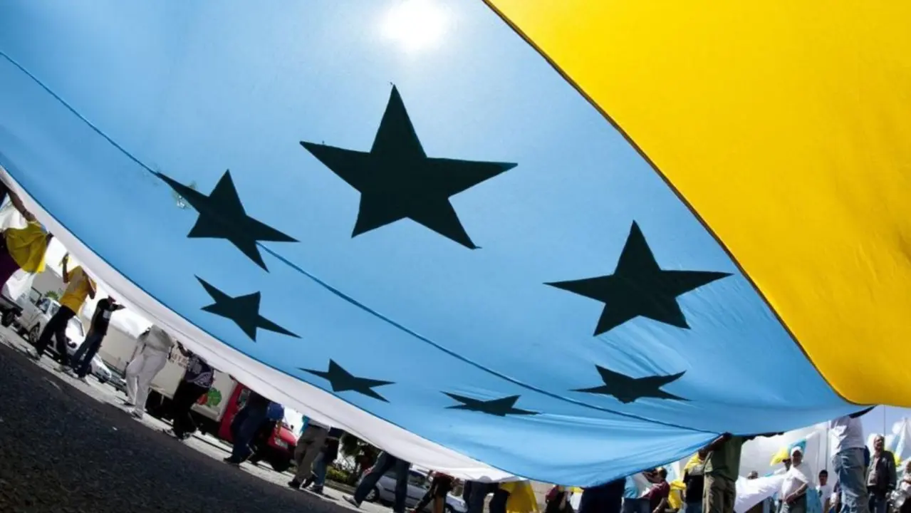 Bandera tricolor con siete estrellas verdes. Imagen de archivo.