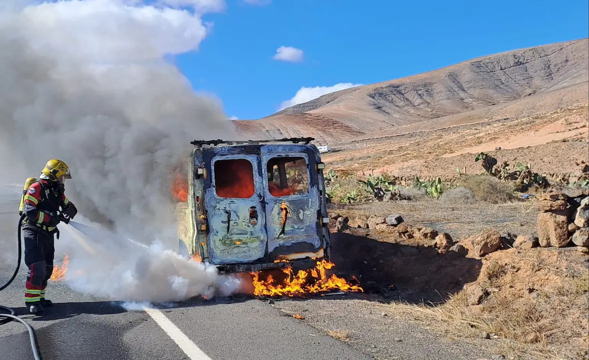 Los bomberos sofocan el vehículo siniestrado.