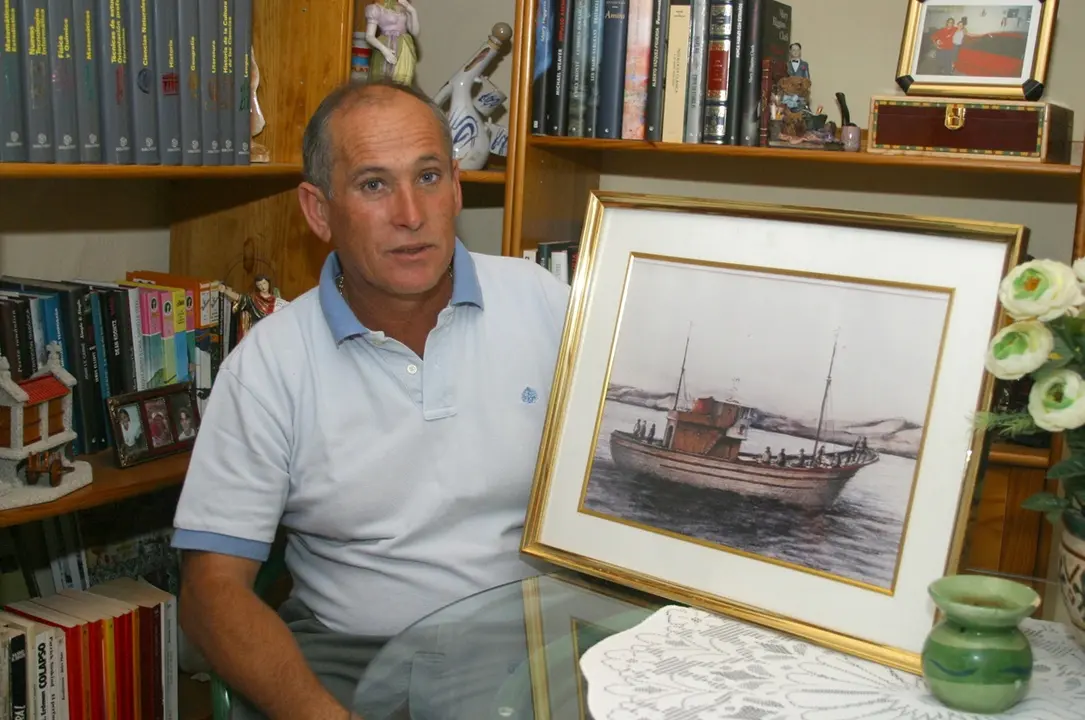 Miguel Ángel Rodríguez García, superviviente, posa junto a un dibujo del Cruz del Mar realizado por Santiago Alemán. Foto tomada por José Luis Carrasco el 11-11-2003.