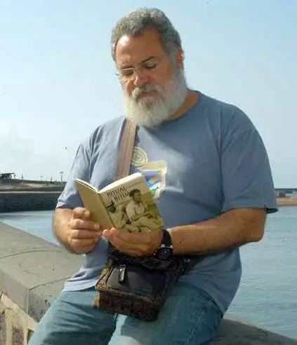 Imagen de archivo del escritor Antonio Félix Martín Hormiga, junto a uno de sus libros en la boca del muelle, en Arrecife (1)