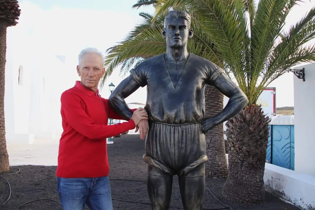 El pregonero Segundo Vi&ntilde;oly junto a la escultura de Joaqu&iacute;n Rodr&iacute;guez 'Pollo'de Uga
