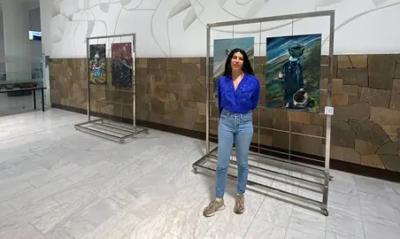 La autora frente a su obra expuesta en la T2