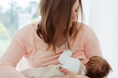 Una mamá da el pecho a su bebé