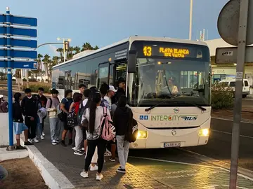 Jóvenes en una parada de guagua de Costa Teguise.