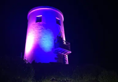 Molino de Yaiza iluminado de color rosa y azul.