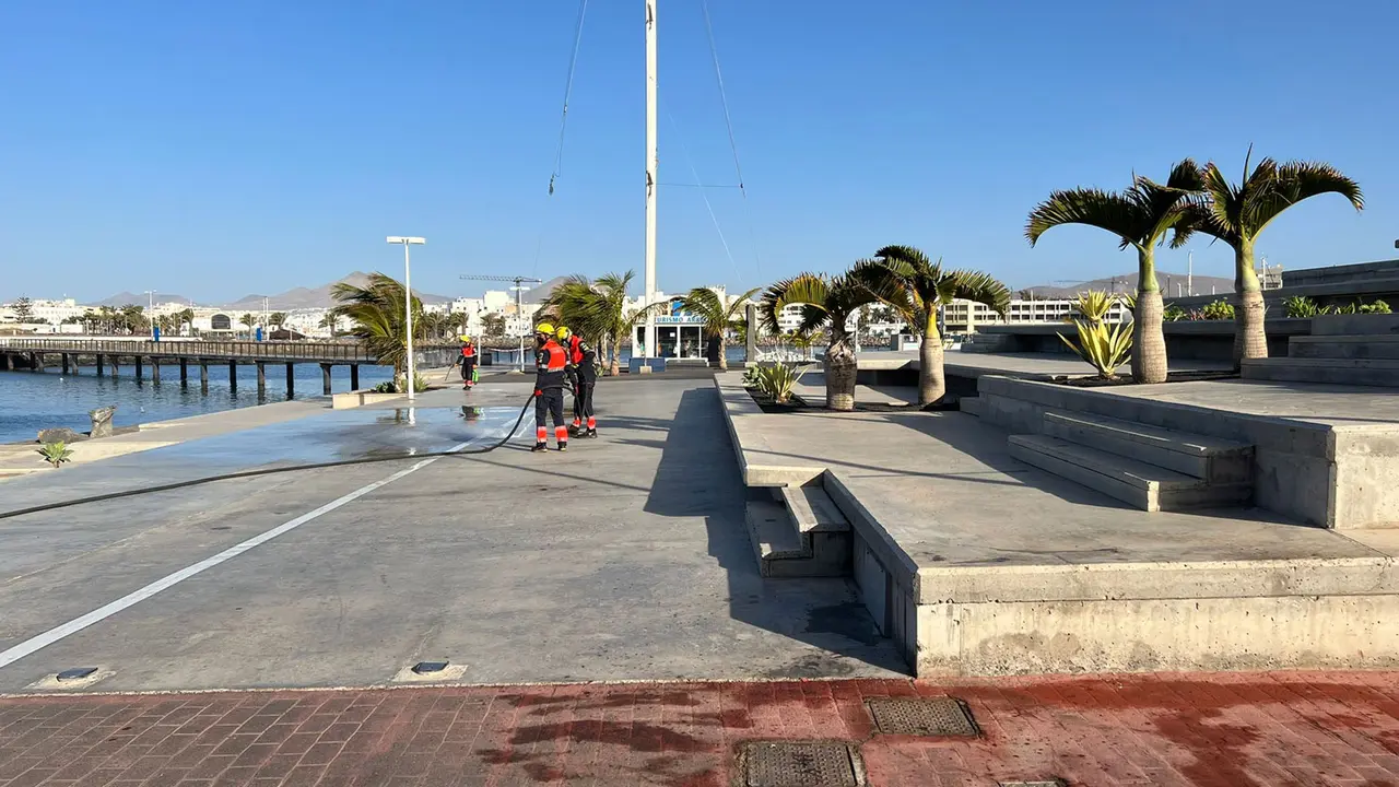 Bomberos limpiando las manchas de sangre
