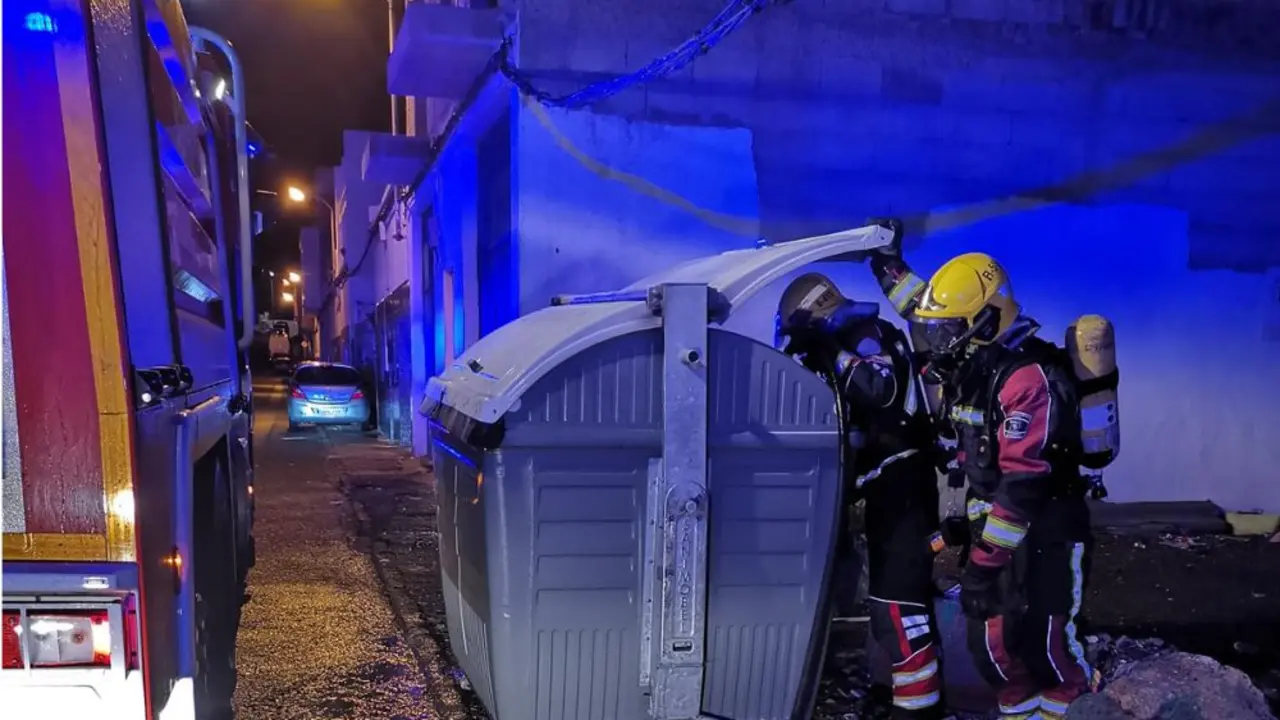 Los bomberos apagando uno de los contenedores
