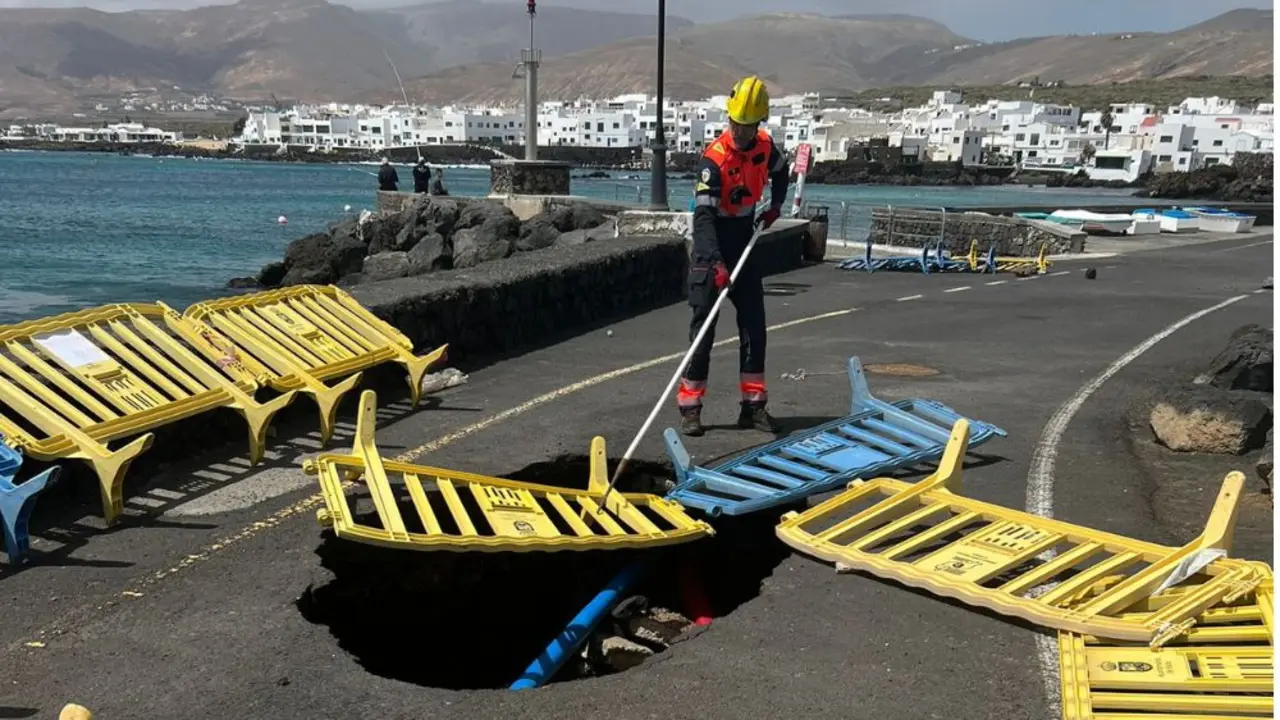Los bomberos colocando las vallas en el socavón de Punta Mujeres