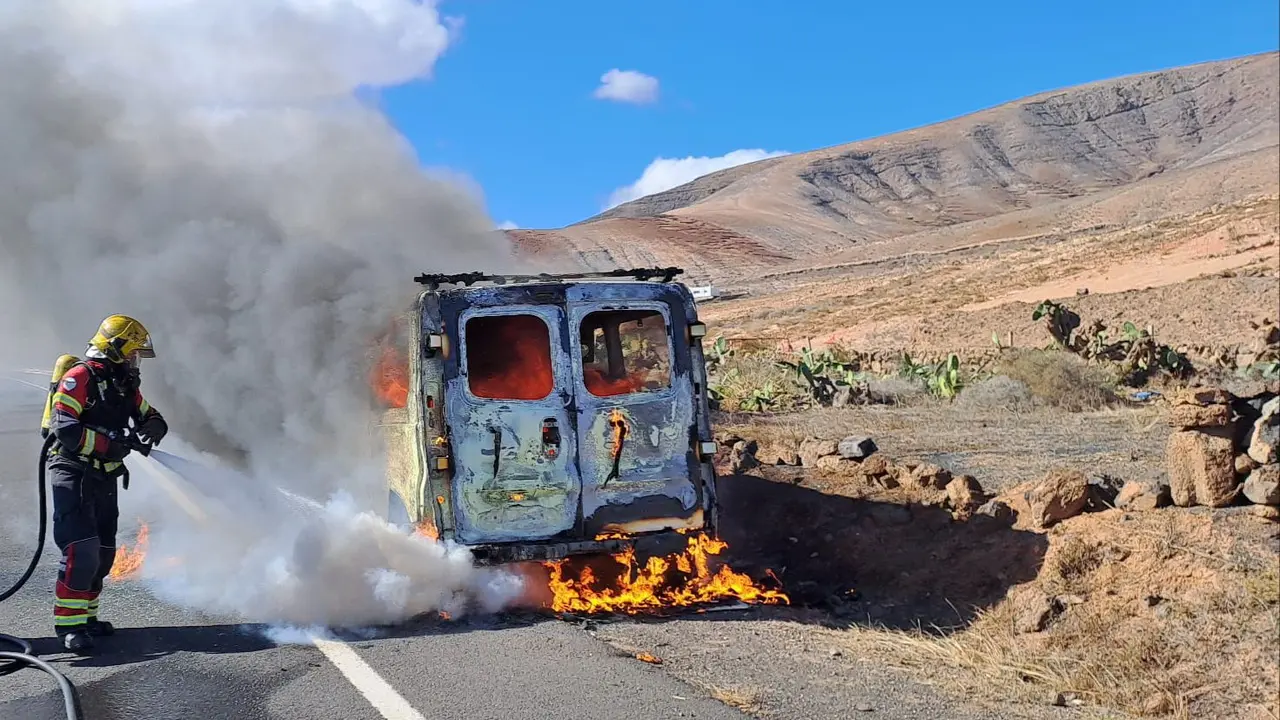 Los bomberos sofocan el vehículo siniestrado.