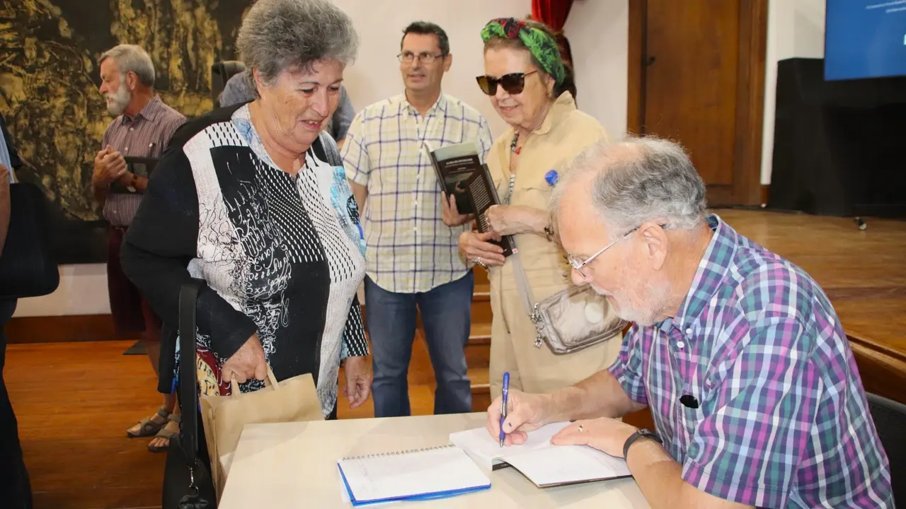 Roger Trend firma de libros tras la presentación.