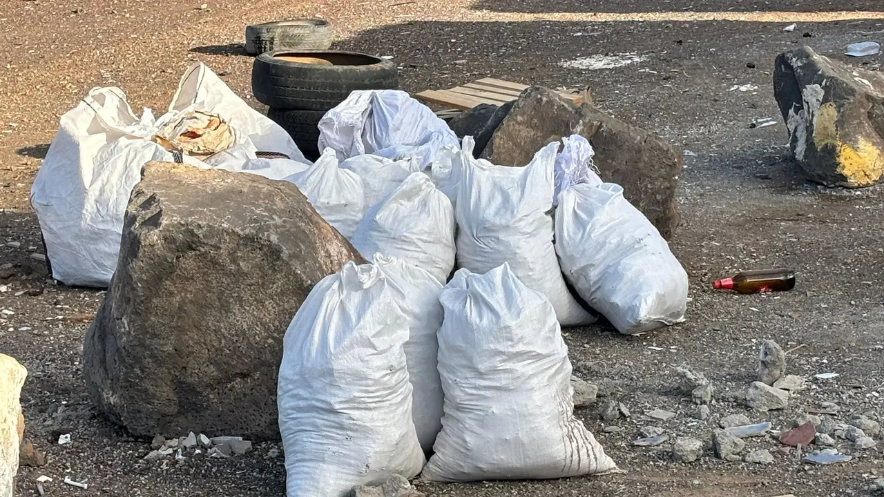 Imagen con las sacas de escombros arrojadas junto a contenedores de basura en un barrio de la capital.