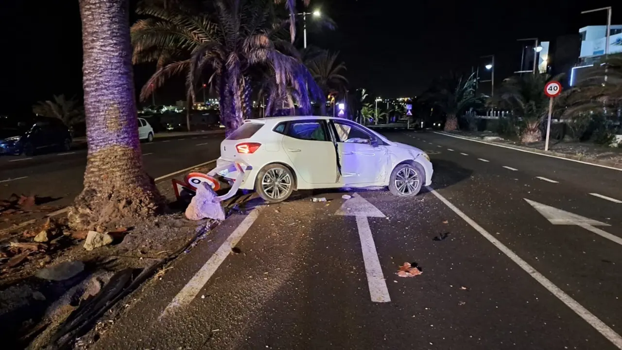 El coche accidentado contra la palmera y la señal de tráfico