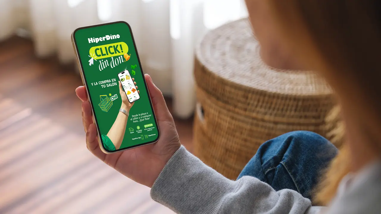 Mockup image of a woman holding mobile phone with blank desktop screen