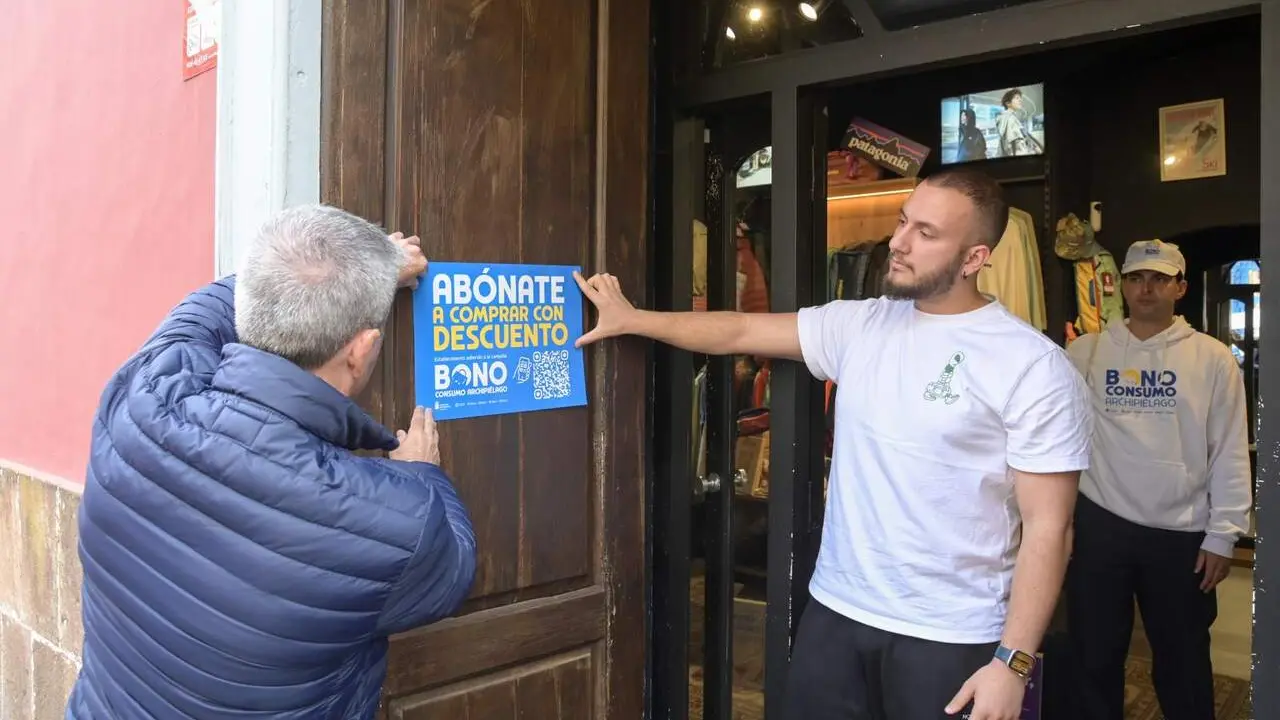 El vicepresidente del Gobierno cuelga un cartel en un establecimiento adherido.jpg