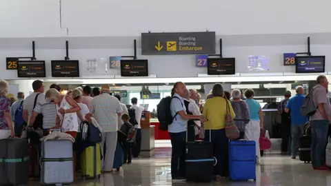 Turistas en el aeropuerto. Imagen de archivo.