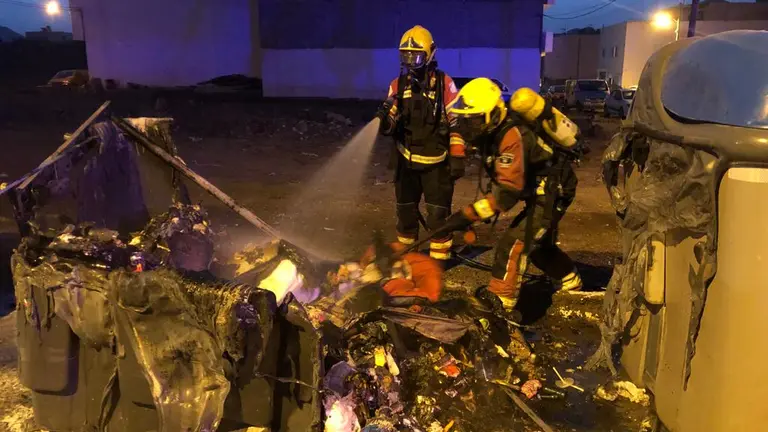 Bomberos apagando contenedores