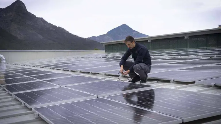 Trabajador de Mercadona en una cubierta de una tienda con paneles solares