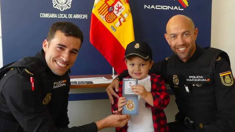 Agentes de la Policía Nacional junto al niño al que salvaron&nbsp;
