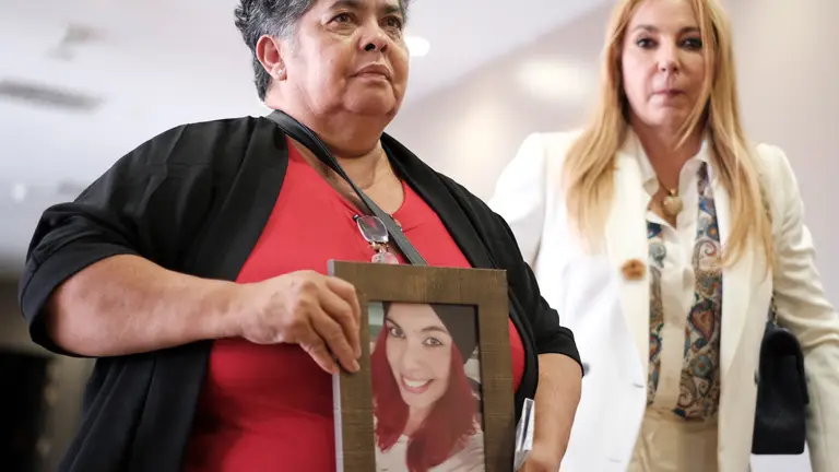 Míriam, la madre de Romina, sostiene un retrato de su hija en presencia de la abogada Emilia Zaballos (FOTO: EFE/Ángel Medina G.)