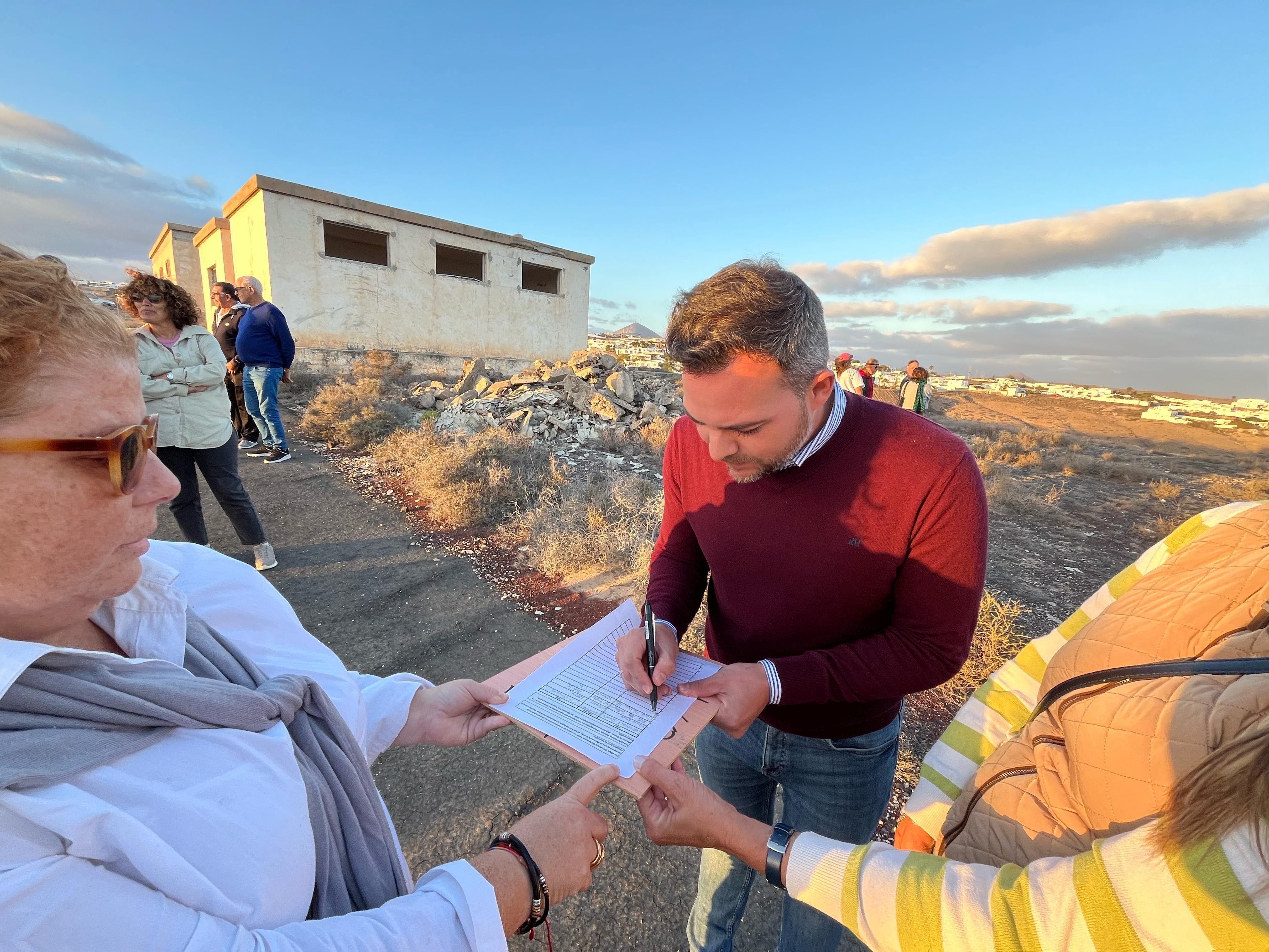 Jacobo Medina firmando en contra del centro de inmigrantes.