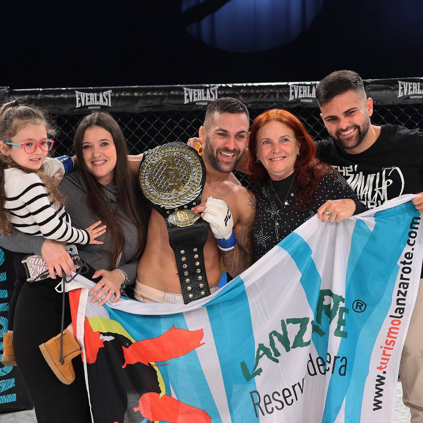 Hecher Sosa,junto a su familia, porta la bandera con el imagotipo de Manrique, tras su triunfo en Suecia.
